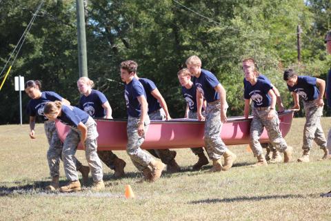 Elbert County JROTC Mix Team members (L-R) Marilyn Flores, Makayla Ingle, Haylee Marunich, Mathew Fernandez, Dean Blanchard, Justin Bastyr, Brandon Nestor, Maelynn Ruff, Gabriel Ruff and Thomas Vaughn race through the physical team test event while holding a canoe during a home Raider meet Oct. 12. (Photo special to The Star). 