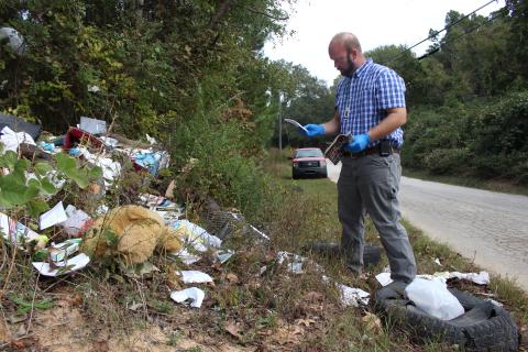Investigation in progress – Allen Hulme looks for clues after he finds dumping in a remote area of Elbert County. (Photo by Scoggins)