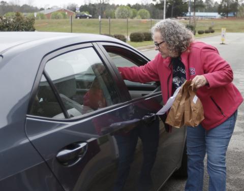 Barbara Bennett assists in distributing lunches called ‘Grab and Go’ at Elbert County Middle School. All schools are preparing student meals for students despite school closures in Elbert County. (Photo by Scoggins)