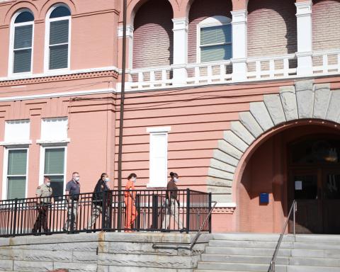 Carrie Jill Peppers is escorted by four detention center officers to the front of the Elbert County courthouse Monday morning to attend her first appearance hearing after being arrested and charged with murder in the second degree and cruelty to children in the second degree.
