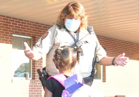 Elbert County School Resource Officer Tammy Gilliard welcomes a student on the first day of school at Elbert County Primary School Monday. (Photo by Jones)