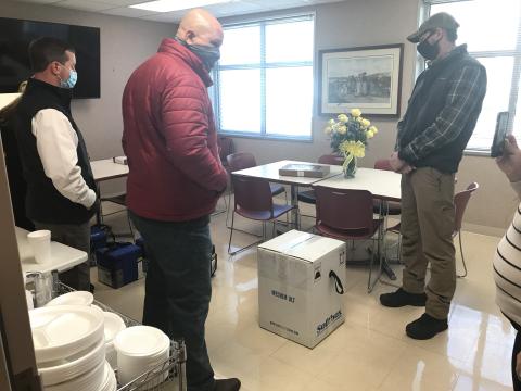 Ryan Rutan (far right), was later identified after Tuesday’s seizure of Pfizer vaccines as an employee of the Georgia Department of Public Health. The two men shown on the left have still yet to be identified. The group is standing around a box full of frozen vials of the Pfizer vaccine. The Elberton Star is sending an open records request to the Georgia Department of Public Health to identify the men and the agency they work for. (Photo by Jones)