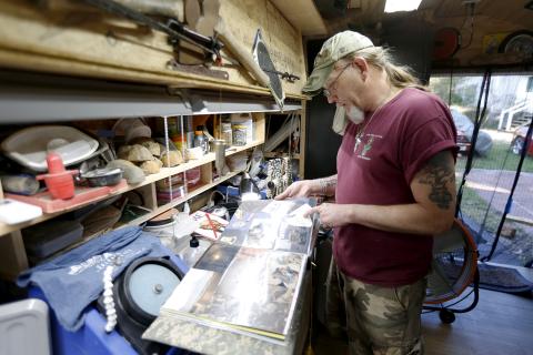 Allen Cartledge looks through a scrapbook from one of his deployments in a shed he has turned into his workshop and “sanctuary” in his backyard. Cartledge was deployed in Iraq from 2009-2010 and in Afghanistan from 2013-2014. (Photo by Scoggins)