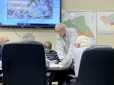 County Administrator Bob Thomas (center) shows the Elbert County Board of Commissioners the first draft of a map that would redraw the county’s districts during the BOC’s work session Thursday, Oct. 7. The county is expected to vote on whether or not to redistrict the county by Nov. 2. (Photo by Scoggins)