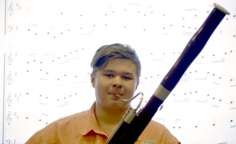 ECCHS senior Kristopher Carter poses in front of his award-winning composition with his bassoon. (Photo by Scoggins) 