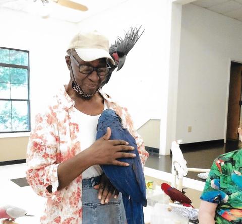 Della Wheeler poses with her new parrot friends during the “Bean and Bird” show at the Bowman Community Center Friday, June 10.