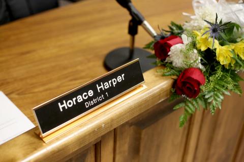 Flowers were placed at Commissioner Horace Harper’s empty seat during Monday night’s regular commission meeting. (Photo by Scoggins) 