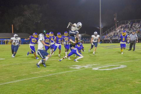 Senior Quan Moss hurdles over a Washington-Wilkes Tiger during Friday’s 32-20 win over the No. 5-ranked Washington-Wilkes High School in Washington.
