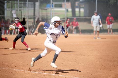Lady Devil Carmen Burden sprints to first base as a Savannah Christian Lady Raider looks to throw her out during a tournament game in Winder Saturday, Aug. 27. (Photo by Scoggins) 