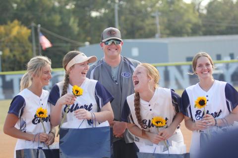 Lady Devil softball seniors (L-R) Jaynee Webb, Lilly Ray, Ava Lunsford and Emalise Andrews laugh during the senior recognition before the team’s final regular season home game Tuesday, Oct. 11. The four seniors were joined by Head Coach Drew Greer. (Photo by Wells) 