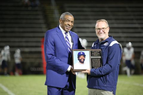 Coach James Clinkscales (left) was honored with a plaque by superintendent Jon Jarvis (right) during Thursday’s homecoming football game. (Photo by Scoggins) 