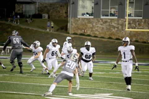 Junior Lucas Alcalde (No. 58), junior Eli Jourolmon (No. 52) and senior Curtis Hall (No. 60) block as sophomore quarterback Javyn Hickman makes a pass during the Devils’ 35-24 win over Whitefield Academy Oct. 7. (Photo by Scoggins) 