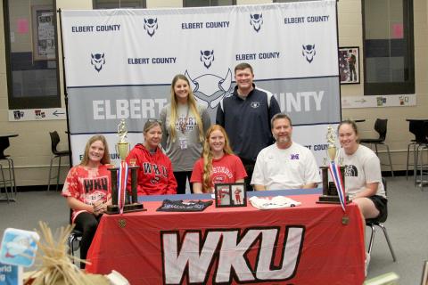 Lady Devil softball player Ava Lunsford signed to continue her softball career at Western Kentucky University Friday, Nov. 11 at Elbert County Comprehensive High School. Pictured during the signing ceremony are (front row, L-R) sister Audrey Lunsford, mom Karol Lunsford, Lunsford, dad Mike Lunsford and sister Elle Luns-ford; (back row, L-R) Coach Bria Bush and Head Coach Drew Greer. (Photo by Wells)