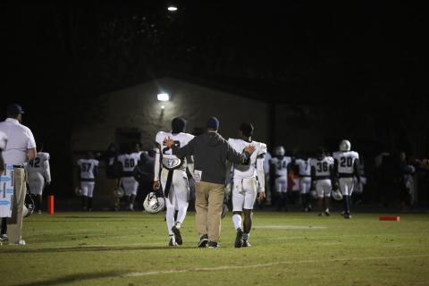 Assistant Coach Mike Williams walks off Prince Avenue’s field with sophomores Malik Hill (left) and Jermaine Sims (right) after the Devils’ 48-14 seasoning-ending loss Nov. 18.