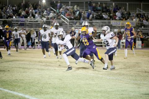 Trustin Allen (No. 5) racks up yards during the game as Eli Jourolmon (No. 52) prepares to ward off an Eagle defender. (Photo by Scoggins) 