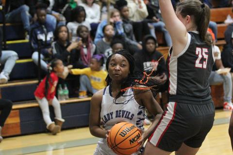 Junior Aameriah Allen dives under a Madison County defender on her way to the basket during the win over Madison County Dec. 9. (Photo by Wells) 