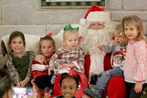 Santa Claus stopped by the Historic Rock Gym to visit families from the Elbert County Sheriff’s Office Thursday, Dec. 17 and received mixed reactions during picture time. Pictured with Santa are (front row) Ariyah Heard and (second row, L-R) Zoey Allen, Madelyn Frady and Lawson Dove, Hadley Frady, Kamdyn Harris, and Kendal Harris. (Photo by Wells)