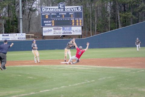 Eli Harris throws the ball towards first base as a Madison County runner slides into second during the Devils’ season-opening scrimmage against the Red Raiders Jan. 31. The Diamond Devils are kicking off the season as the No. 9 team in the state for the AA classification and are coming off last year’s region championship-winning season. The regular season kicked off Monday against Habersham. (Photo by Wells)