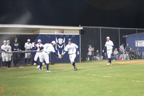 Head Coach Lance Ingram (left) congratulates Skylar Bray (right) as he runs home after knocking out a grand slam during the Devils’ 9-4 win over Hart County Feb. 8 at Diamond Devil field. (Photo by Wells)