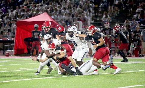 No. 54 Seneca Turner and No. 42 D.J. Fortson wrap up the Harlem quarterback in the backfield late in the game. (Photo by Wells)