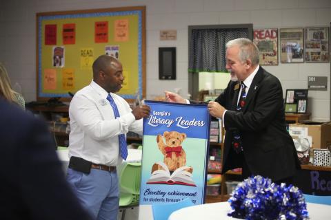 State School Superintendent Richard Woods (right) presents Elbert County Elementary School Principal Jasper Huff with a banner celebrating the school being named one of the state’s Literacy Leaders. (Photo by Wells)