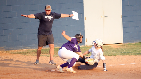 Head Coach Drew Greer signals “safe” after Miller Drake slides into third base. Drake was one of seven different Lady Devils to steal a base against Athens Christian. (Photo by Wells)