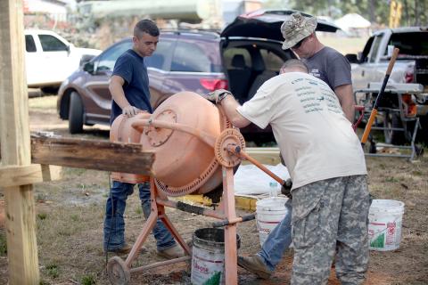 Colton Mabry (left), Sgt. 1st Class Otis Cadd (top right) and Sgt. 1st Class Dan Ulrich (bottom right) mix cement for the JROTC program’s new obstacle course at Elbert County Comprehensive High School Oct. 6. (Photo by Wells)