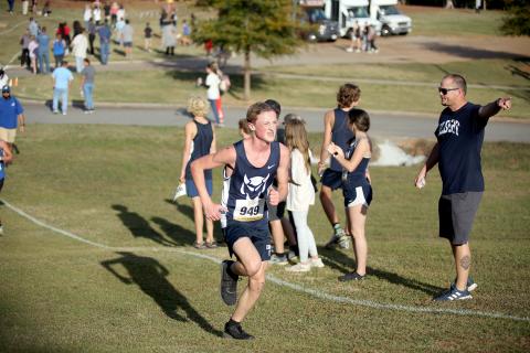Head Coach Kyle Ashworth points up the track as Ezra Adamson runs by during the Region 8A Division 1 championship meet. (Photo by Wells)