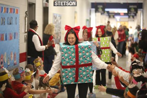 Elbert County Primary School (ECPS) first grade teachers (front to back) Ashley Mills, Brianna Bowen and Kaitlin Walker high five students while dressed as presents during the ECPS Christmas Parade Dec. 13. The parade included teachers and faculty dressed up in festive Christmas attire and included a special visit from Santa Clause himself. (Photo by Wells)