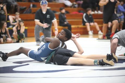 Ny’Zaevion Merriett looks to his coaches as he attempts to pin a Youth Middle School wrestler during Elbert’s exhibition matches. (Photo by Wells)