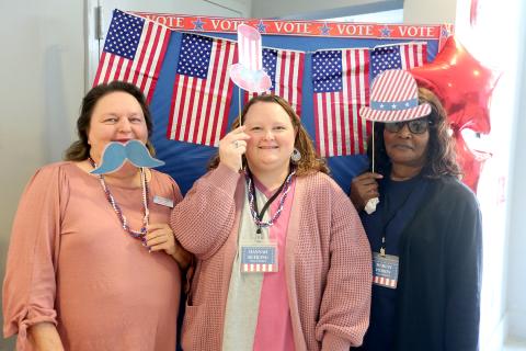 Elections Supervisor Melissa Shead (left) and poll workers (L-R) Hannah Kuhling and Marian Perrin pose for a picture in the foyer of the Historic Rock Gym. A "selfie station" has been set up for voters to take a picture with props after casting their vote in the Presidential Preference Primary. Photos can be shared with the Board of Elections and Registration Office by emailing voteec@elbertga.us for a chance to be featured on the office's Facebook page. (Photo by Scoggins)