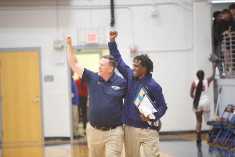 Head Coach Josh Jones (left) and Assistant Coach Donald Bolton (right) celebrate with the traveling Elbert fans after the Lady Devils pulled off an upset of No. 1 seed Oglethorpe in the first round of the GHSA State Playoffs. (Photo by Wells)