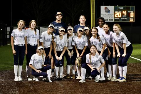 The Lady Devils slow pitch softball team poses in front of the scoreboard after beating LaGrange 20-0 to advance to the Elite Eight round of the GHSA State Playoffs. (Photo courtesy of Elbert County True Blue)
