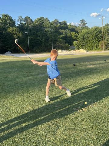 Youth golfer Benson Holland takes a swing at the ball during the Elbert County Future Blue Devil Golf Camp held June 17, June 18 and June 20. (Photo courtesy of Larry Kesler)