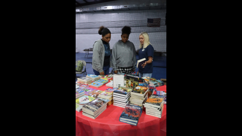 During the Pleasant Grove Baptist Back to School Bash Elbert County Comprehensive High School senior Nathalia Aquino and Elbert County Middle School eighth grader Nalleoi Aquino discuss book titles with Tanya Long, retired Director of Teaching and Learning for Elbert County Schools. (Photo by Weeks)