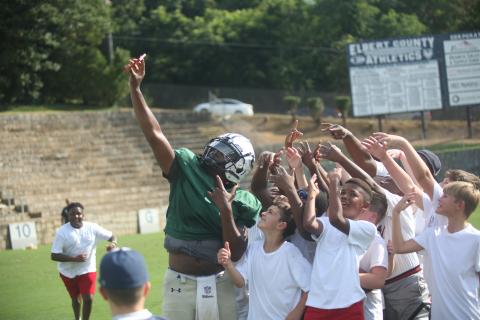 Left, Quarterback Jayvyn Hickman (far left) takes a selfie with a host of young Devil fans using one of the fans’ phones during last year’s Community Kickoff. (File photo by Wells)