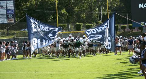 Charging through the first run-through sign of the season, the ECCHS Blue Devils take the field at the Friday Night Lights Community Kickoff Friday, Aug. 9 in the Granite Bowl. The Devils ran various plays and drills and had a practice scrimmage during the event while fans watched from the stands.  Also on hand this season's new cheerleading squads, band and auxiliary members and youth league football and cheerleading squads. (Photo by Weeks)