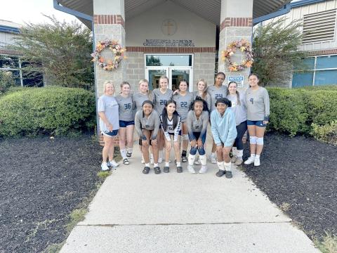 The Lady Devils volleyball team poses for a team picture outside Monsignor Donovan’s gym after winning a pair of games over the Lady Rams and George Walton Academy Sept. 19. (Photo by Wells)