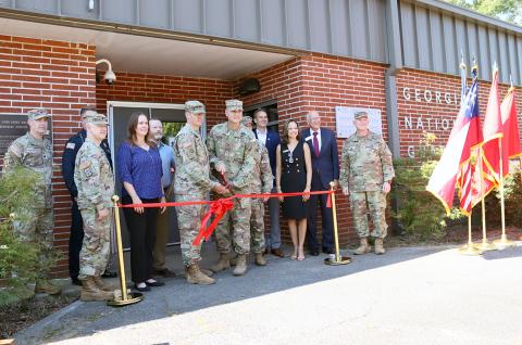 Georgia Army National Guard members along with local city, county and state officials look on as Captain Elisha Campbell and Brigadier General Jason Fryman cut the ribbon signalling the re-opening of the local National Guard Armory. (Photo by Weeks)