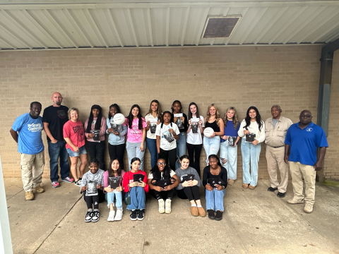 Pictured with some of the donated equipment are (front row, L-R) De’Shayla Jackson, Jessica Flores, Lindsay Castro, Trania Skelton, Amelia Phillips and Aerial Oglesby and (back row, L-R) Freddie Baker, Assistant Coach Shaun Human, Head Coach Anya Human, Anaja Banks, Shamya Davis, Dayana Mota, Melanie Badillo, Lakeria Bradley, Shania Huff, Peyton Roach, Cadence Noggle, Kendall Baston, Zurina Dillard, James Jordan and Alfred Dye. (Photo by Wells)