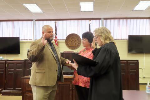 Incoming sheriff Jamie Callaway (left) is sworn in by Probate/Magistrate judge Stephanie Hewell(right) as Callaway's wife, Jill (center) assists by holding the Bible. (Photo by Weeks)