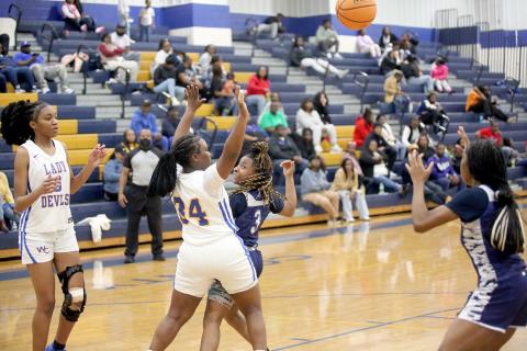 Zoe Evans (left) passes behind her back to Aaliyah Allen (right) during Elbert’s win over Warren County Jan. 18. (Photo by Wells)