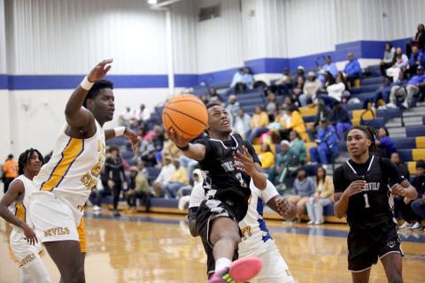 Jordan Morrison leaps as he lays the ball in with one hand in between a pair of Screaming Devil defenders during Elbert’s loss to Warren County Jan. 18. (Photo by Wells)
