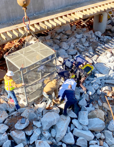 EMS team members move the injured worker onto the gurney prior to loading him into the quarry box to be lifted to safety. (Photo courtesy of Elbert County Emergency Services)