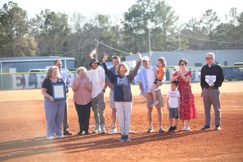 Kim Harper Bray (center) waves to the crowd during her jersey-retirement ceremony in between the Lady Devils softball team's doubleheader against Johnson March 12. (Photo by Wells)