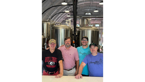 Normaltown Brewing’s majoroity owners Scott Fortson,  David Abernathy, Erich Fietkau and Phil Fortson stand in front of the tanks in the facility on Barber Street in Athens. (Photo submitted by Scott Fortson)