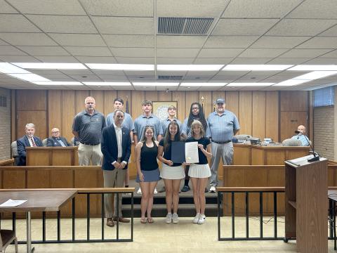 Pictured with the proclamation are (front row, L-R) Elberton Mayor Daniel Graves, Coach Emalise Andrews, Sophie Lavender, Camdyn Moon and (back row, L-R) Head Coach Larry Kesler, Nolan Henderson, Brayden Edwards, Carson Amabile, Caleb Burton and Coach Sandy Thornton. (Photo by Wells)