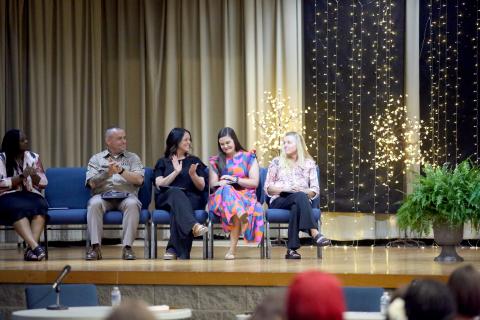 Elbert County Primary School first-grade teacher Meredith Lawson (second from right) learns that she was named district teacher of the year while SFC Daniel Ulrich (far left), Wendy Collier (second from left) and Tina Lunsford (far right) congratulate Lawson during the Elbert County Board of Education's May 19 regular meeting in the Elbert County Middle School auditorium. (Photo by Wells)