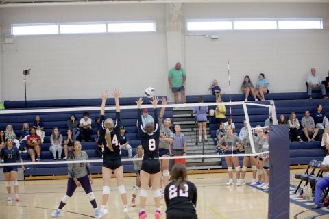 Alexa Vargas carefully tips the ball over the net above a pair of Rabun County opponents. (Photo by Bo Underwood)