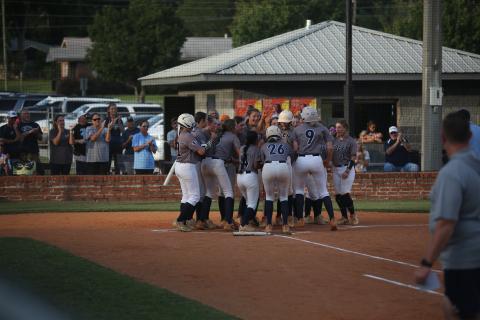 The Lady Devils softball team swarms Ky Dubose at home plate after she hit a home run in their rescheduled game against Hart County Aug. 27. (Photo by Bo Under